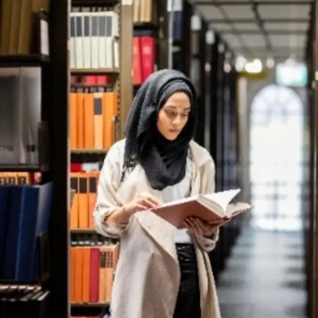 A woman is reading in the library.